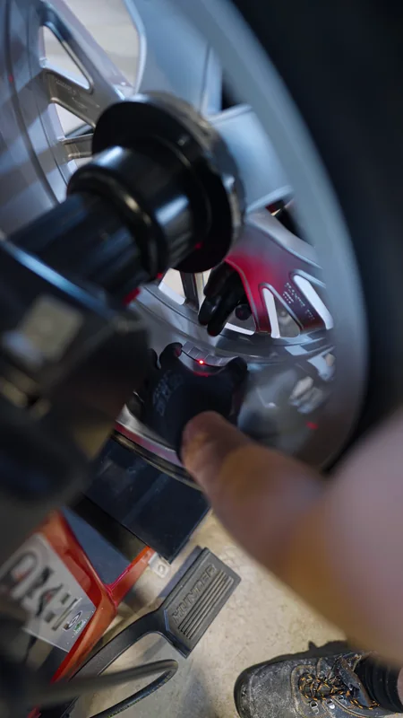 AutoLAB darbuotojas deda balansavimo svarelius vidinėje ratlankio pusėje